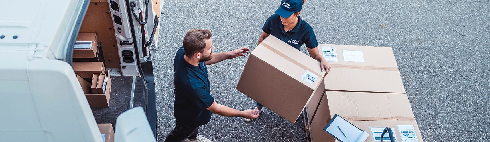 Frete Spot: um entregador faz a entrega de mercadoria numa caixa a uma funcionária da empresa