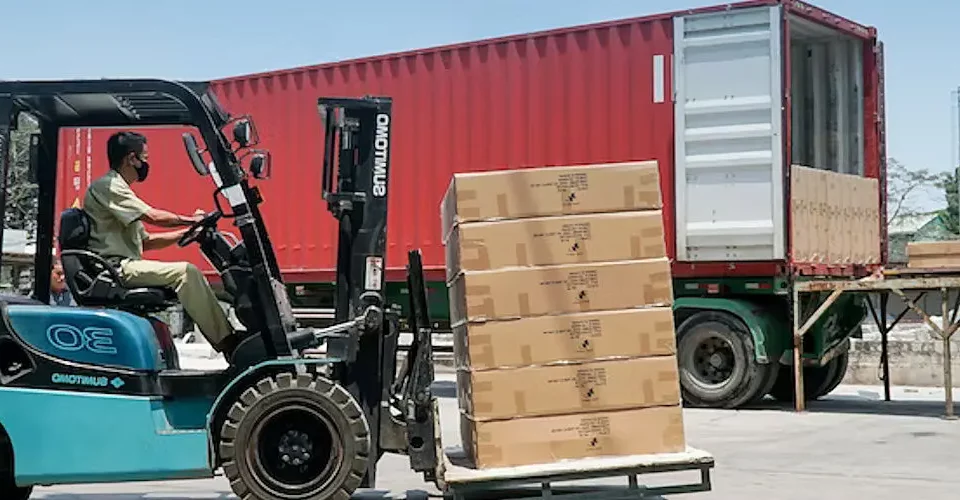 Transbordo de carga: uma empilhadeira carrega um caminhão