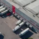 Operadores logísticos: caminhões saindo de um armazém