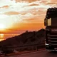 Por que escolher a Bsoft: caminhão passando em uma estrada com o por do sol ao fundo