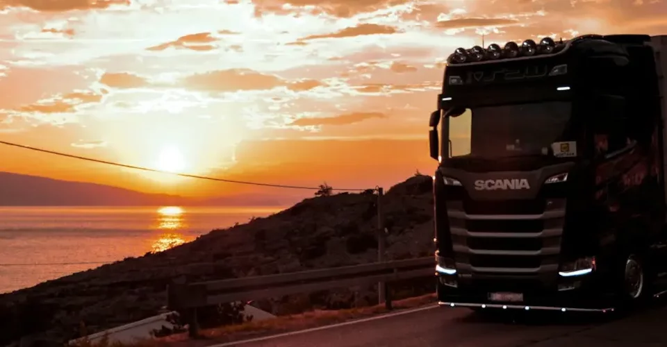 Por que escolher a Bsoft: caminhão passando em uma estrada com o por do sol ao fundo